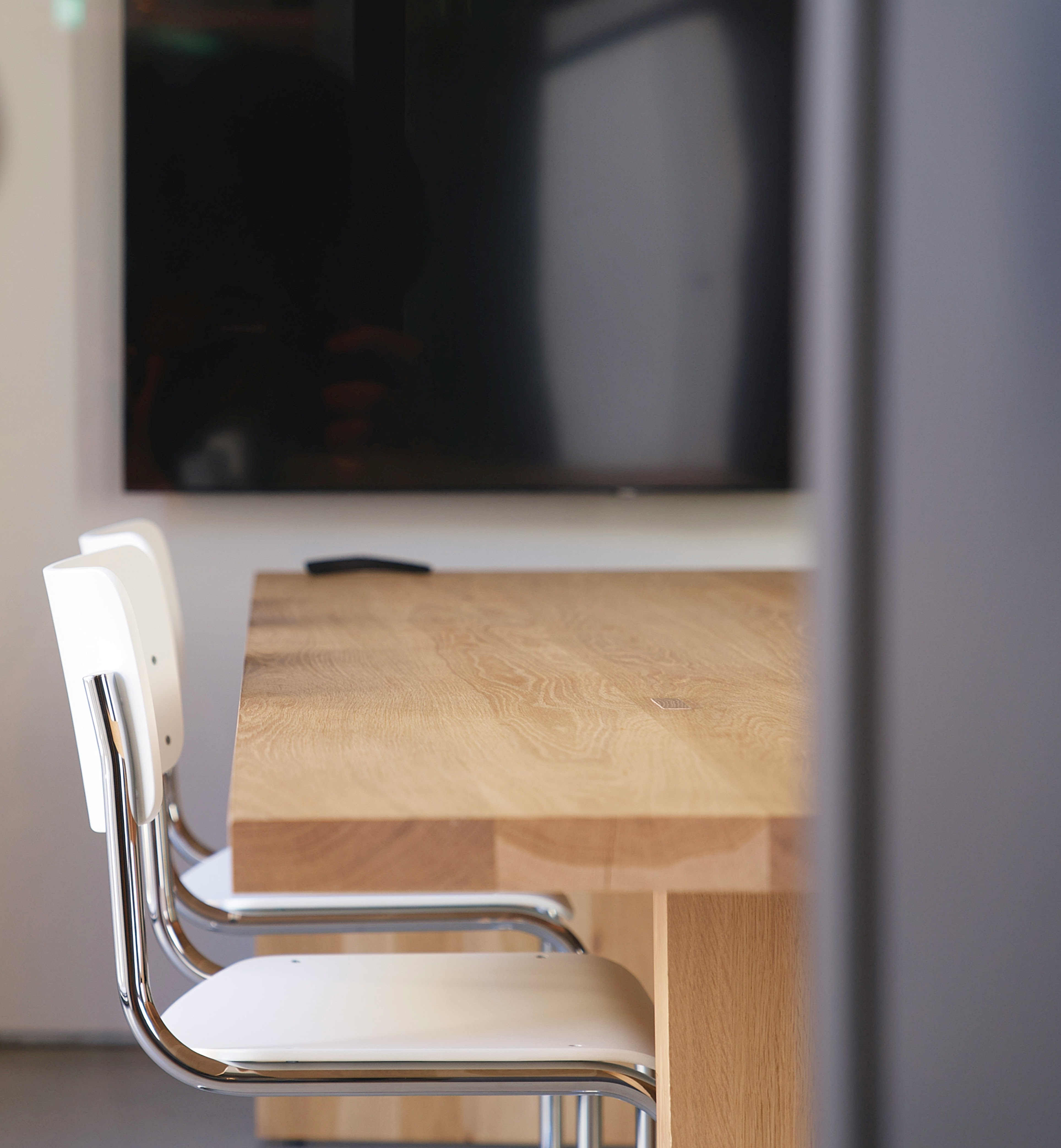 Empty chair at a meeting table in a quiet office, representing a difficult workplace conversation about feedback and leadership.