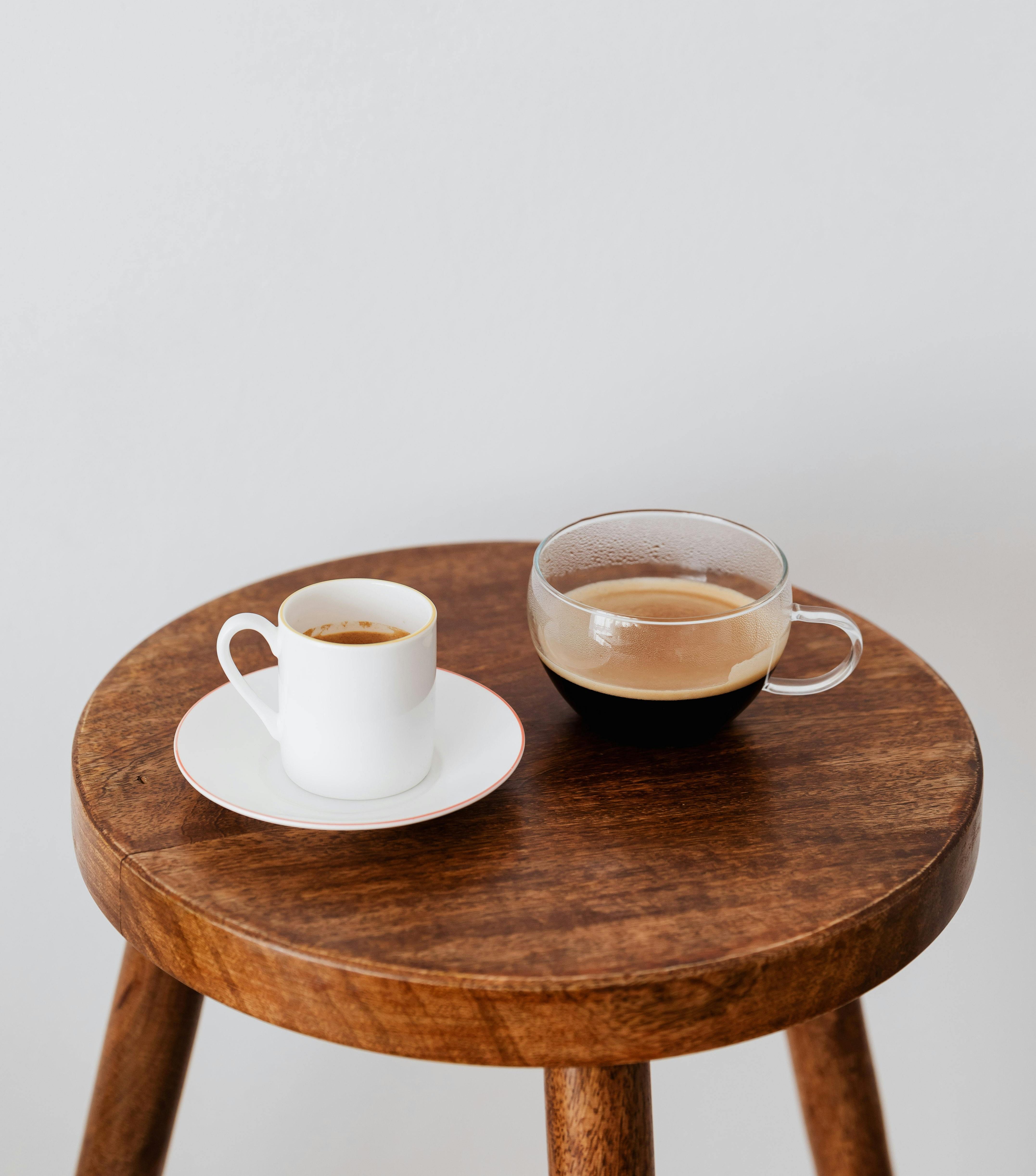 Two cups of coffee on a wooden table representing a calm coaching conversation at work