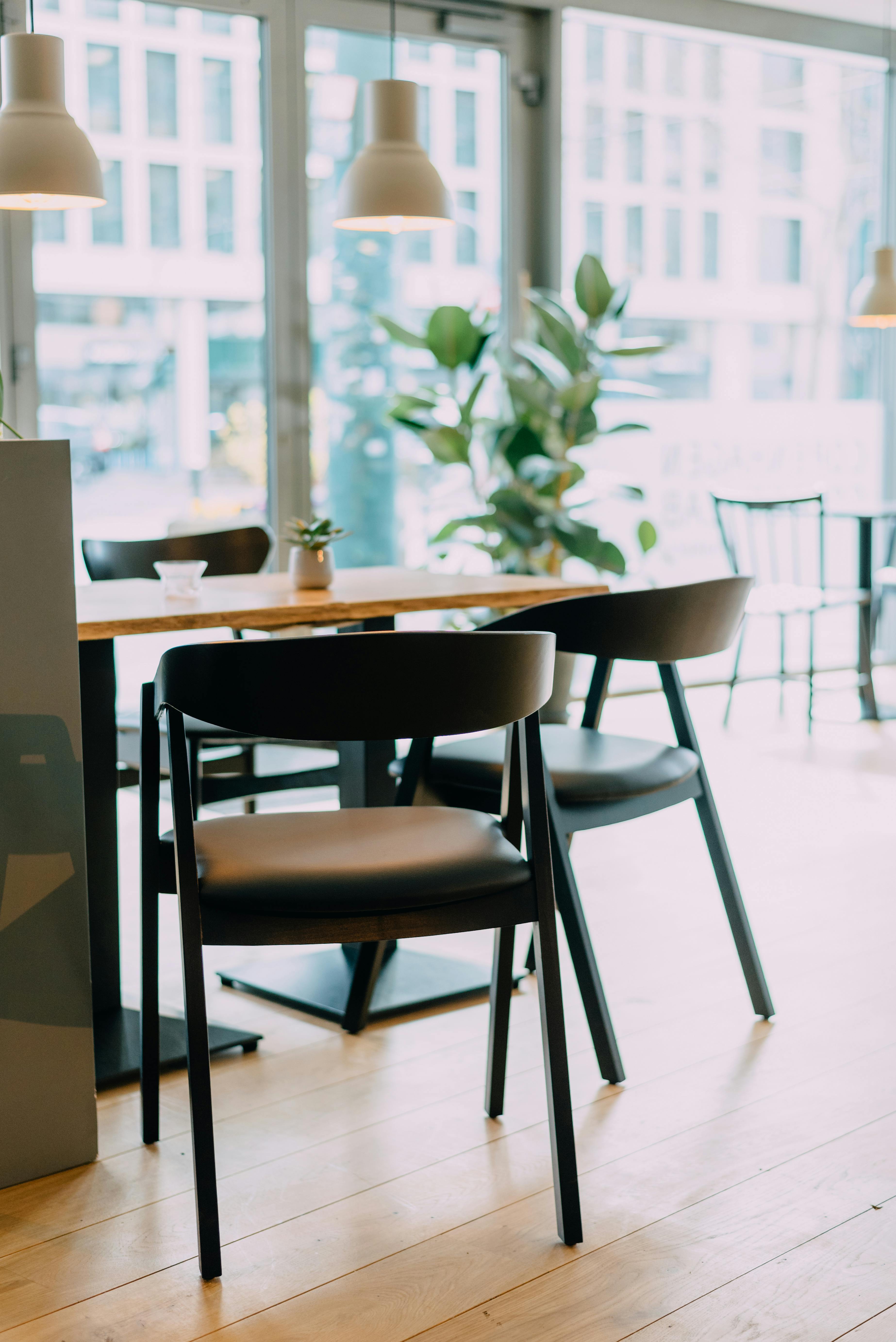 Minimal office meeting space with chairs, table, and soft natural light, representing calm workplace conversations and leadership.